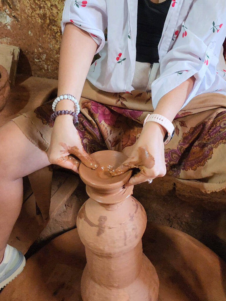 Beginner shaping wet clay on a pottery wheel in Avanos