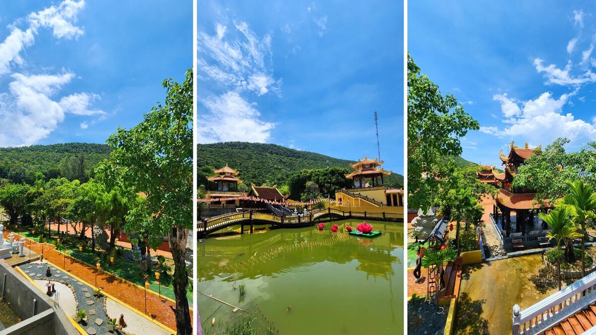 Overview of the Ho Quoc Pagoda complex with a bridge over a green pond and pagoda rooftops set against forested hills