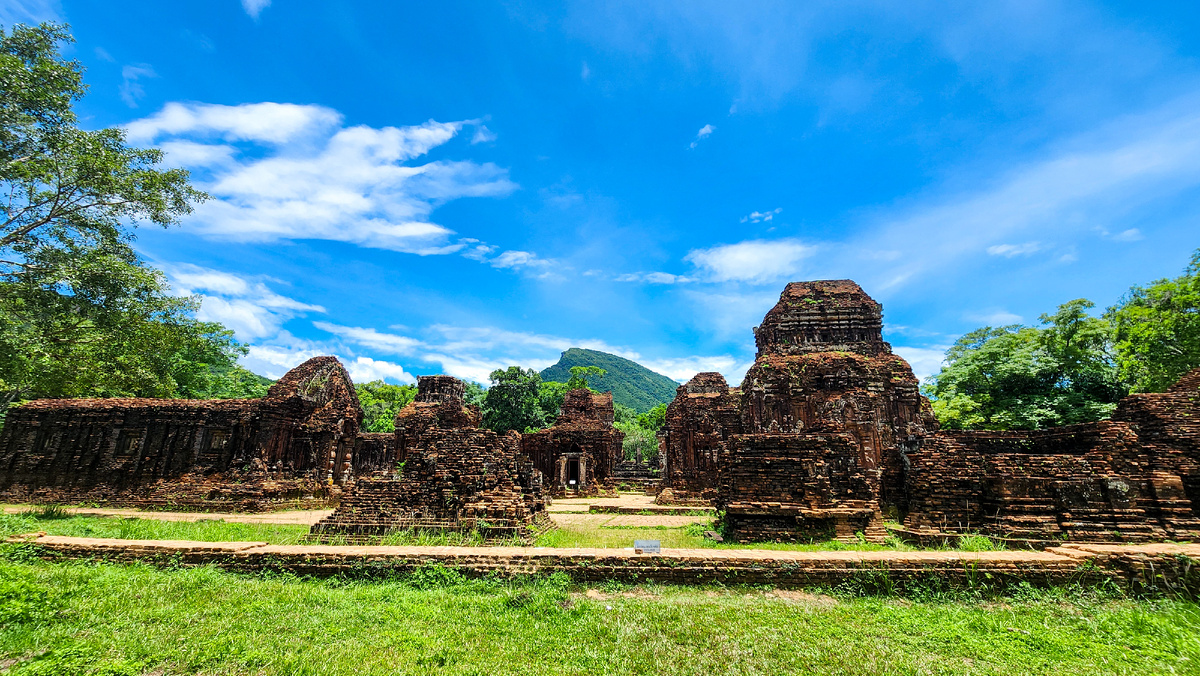 Brick temple towers at My Son Sanctuary beneath a bright blue sky